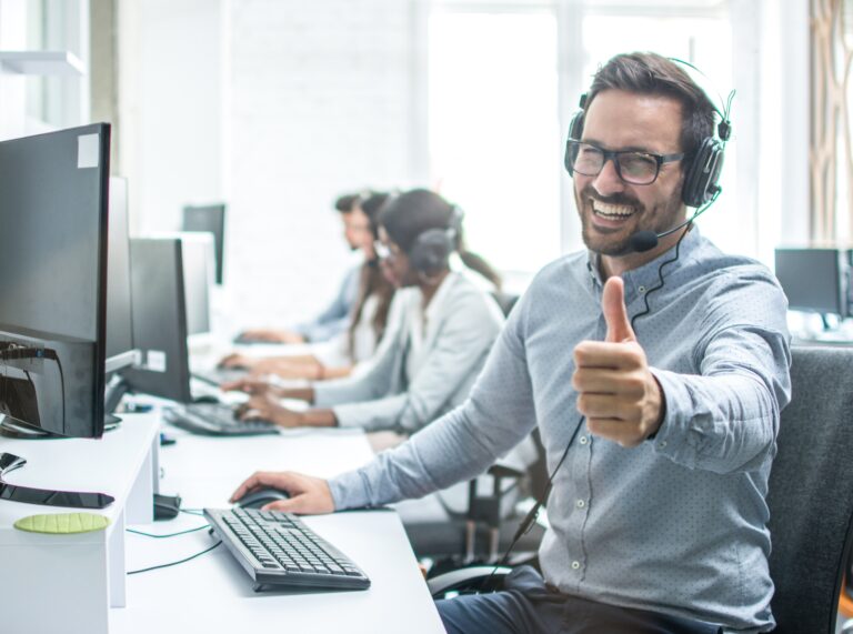 A man giving the thumbs up while wearing headphones.